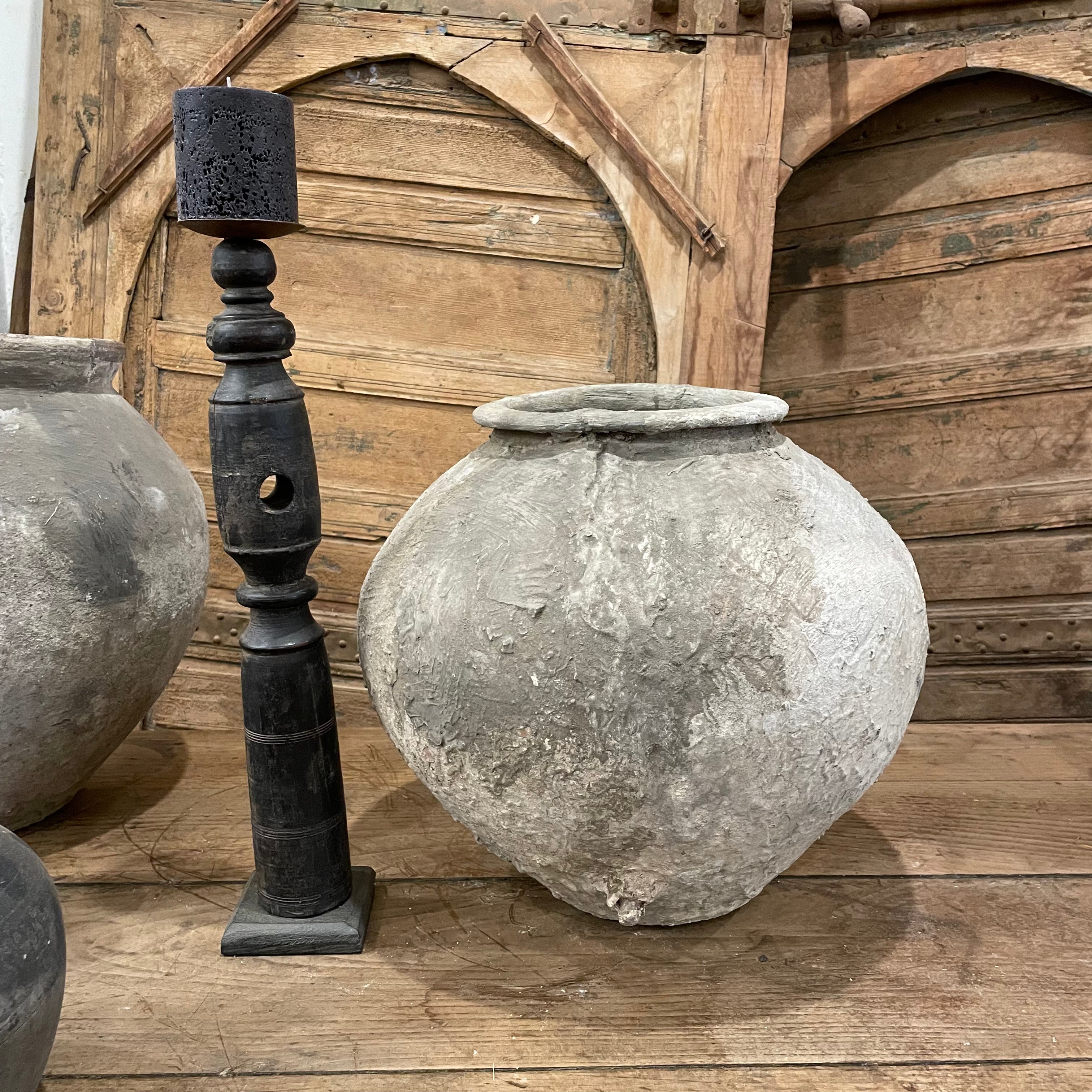 Decorative stone urns and a black lamp post against a wooden background
