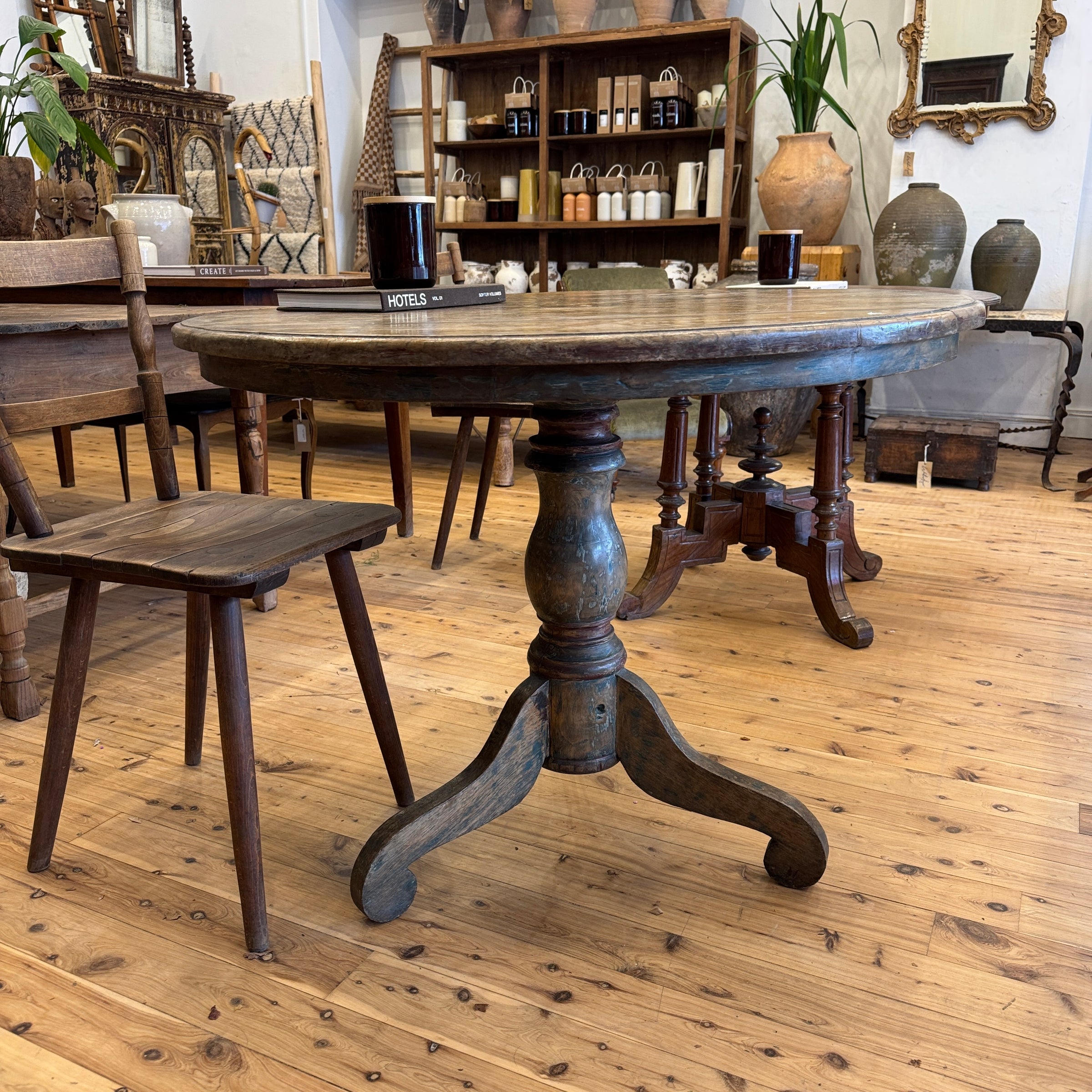 Wooden dining table with chairs in a room with wooden flooring and decorative items.